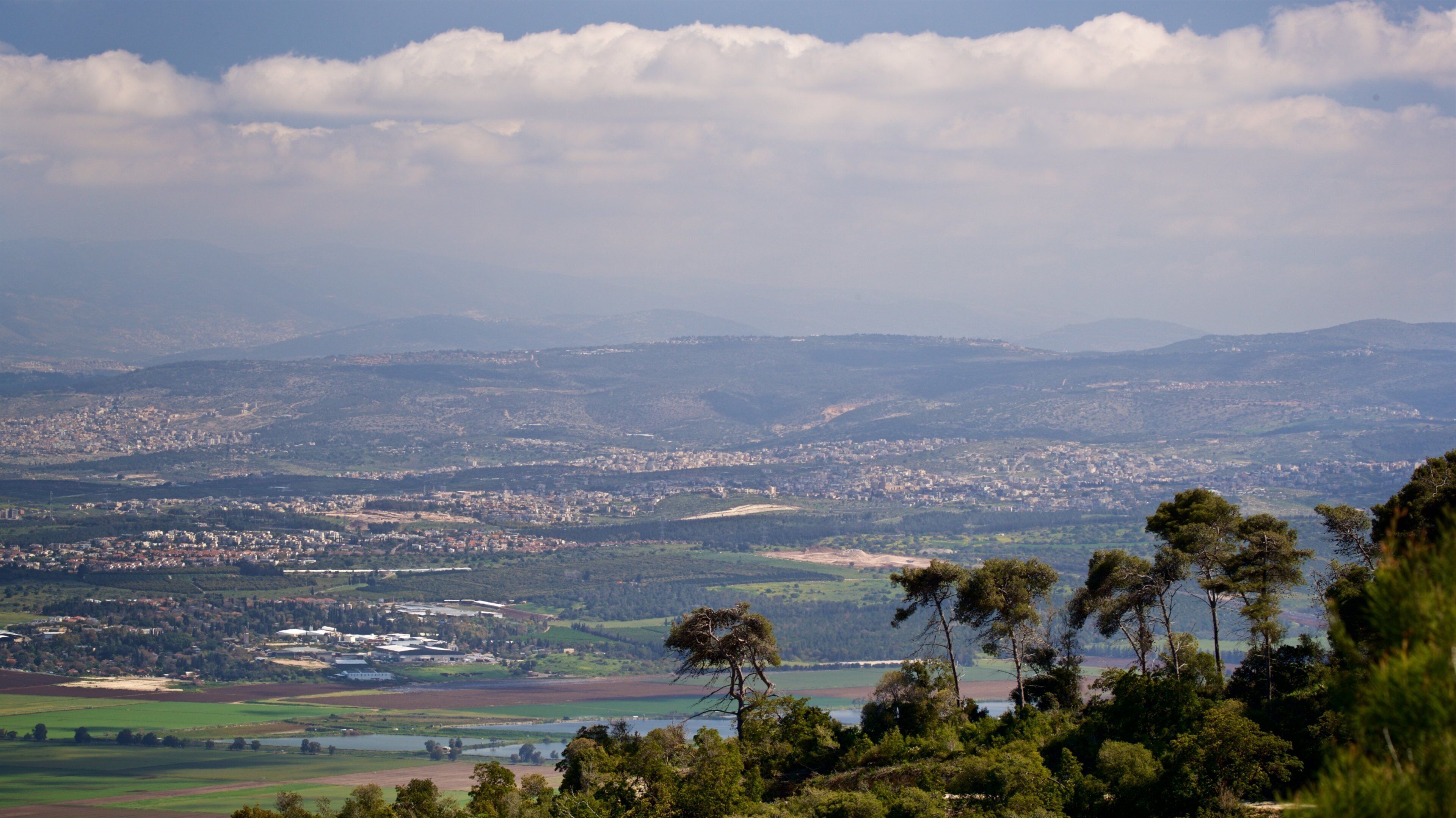 A panoramic view of a city surrounded by hills and mountains.
