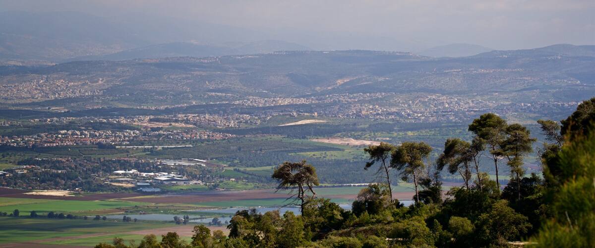 A panoramic view of a city surrounded by hills and mountains.