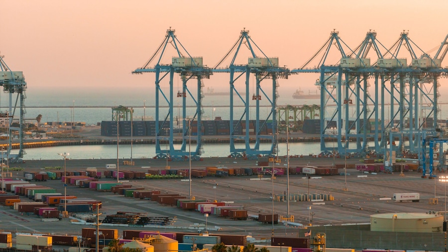 A port with multiple cranes and shipping containers.