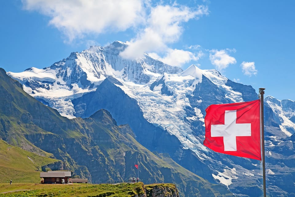 A mountain range with a Swiss flag.