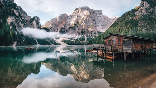 Panoramic view of Braies Lake with the hut and boats in Dolomites mountains and Seekofel in the morning, Sudtirol, Italy