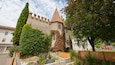 Un castillo con muros cubiertos de hiedra y un techo cónico.