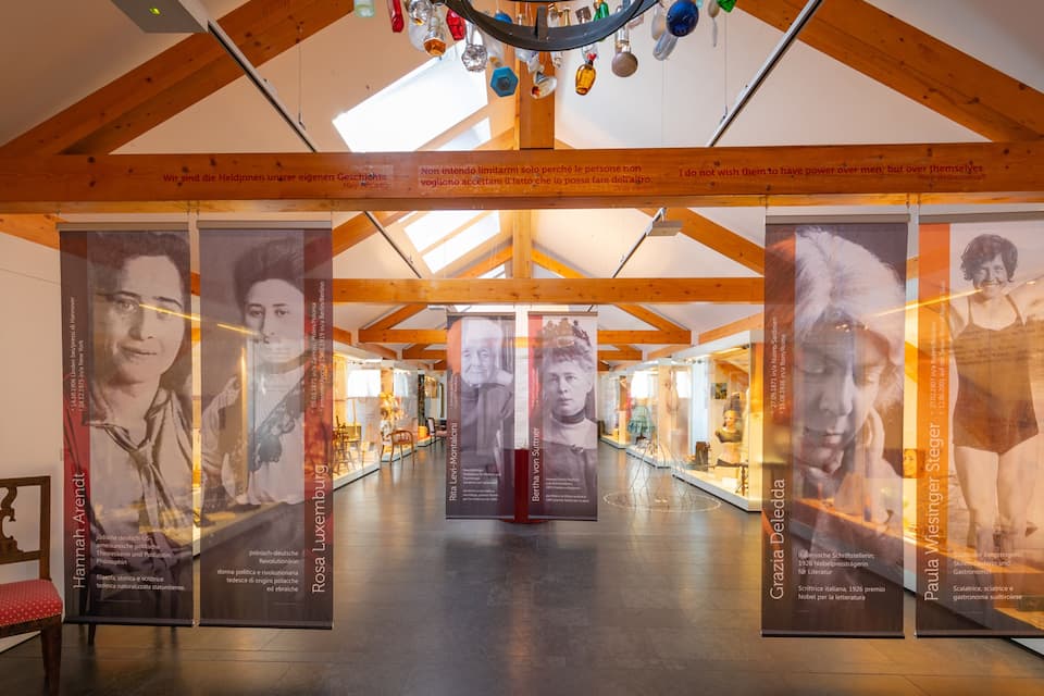 Ein Museumsflur mit Holzbalken und Glastausen.