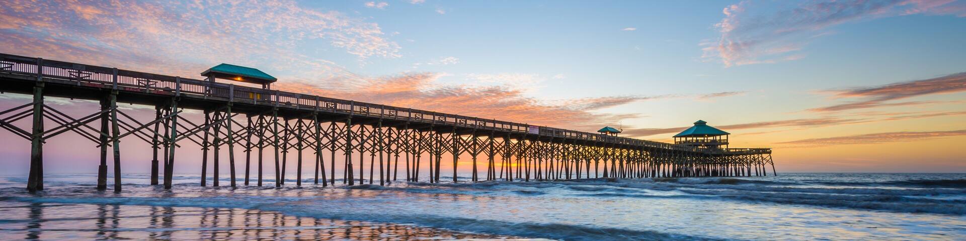 Waves in the Atlantic Ocean and the pier at sunrise, in Folly Be
