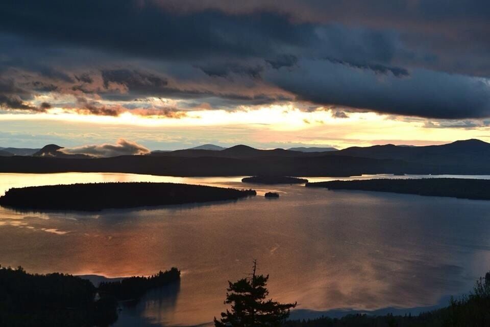 A lake surrounded by mountains at sunset.