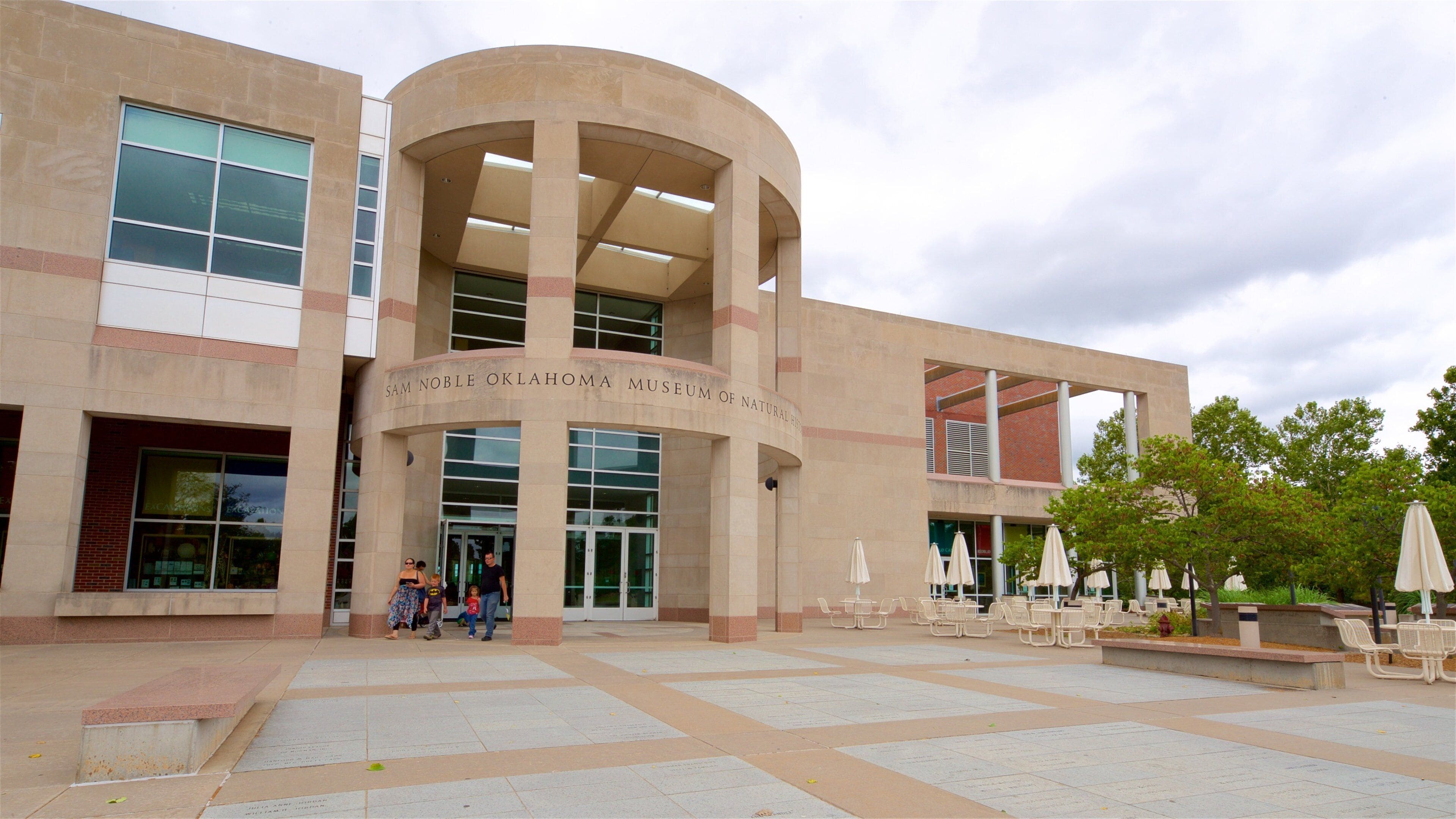 The Sam Noble Oklahoma Museum of Natural History building with a curved entrance and outdoor seating area.