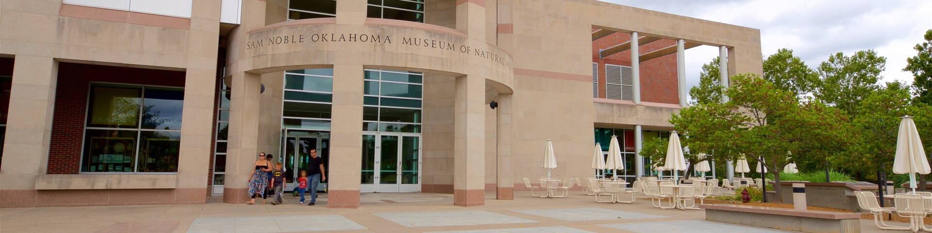 El edificio del Museo Sam Noble de Historia Natural de Oklahoma, con una entrada curva y una zona de estar al aire libre.