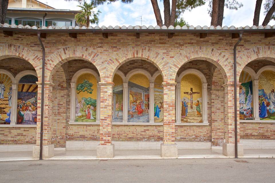 Ein Backsteinhaus mit rundbogigen Fenstern, die religiöse Mosaike zeigen.