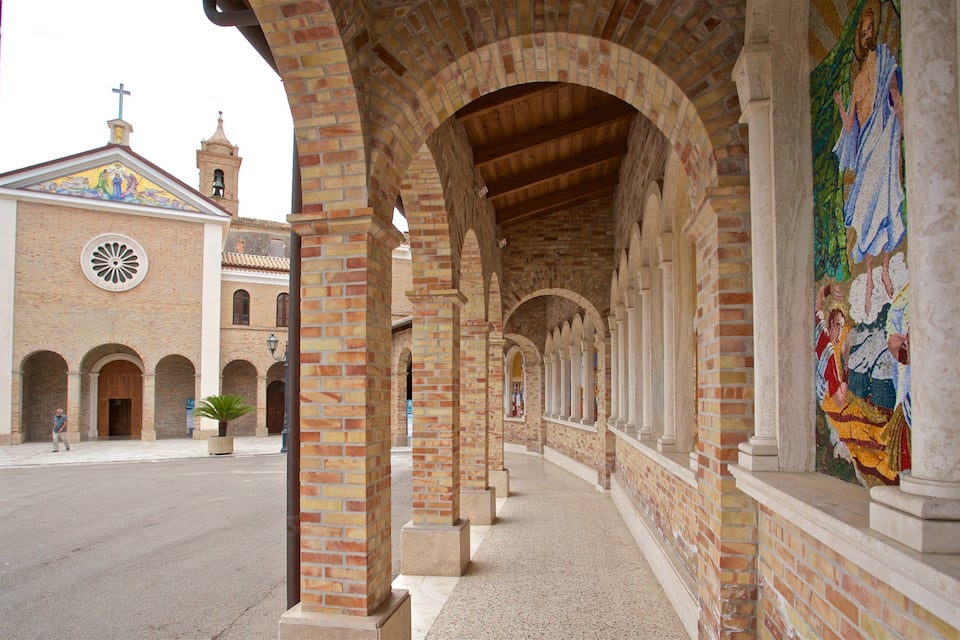 A covered walkway with brick arches and a mosaic mural.