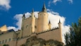Un castello con numerose torri e un muro in pietra.