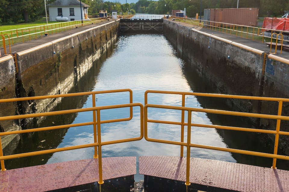 A canal with yellow railings and a bridge.