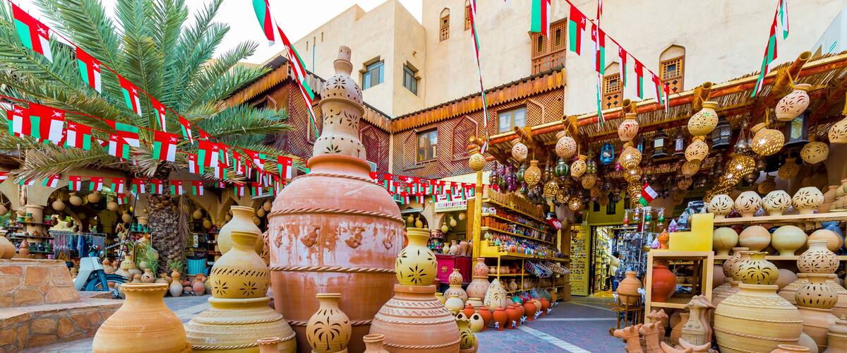 A market with large pottery and ceramic items displayed on the ground and shelves.