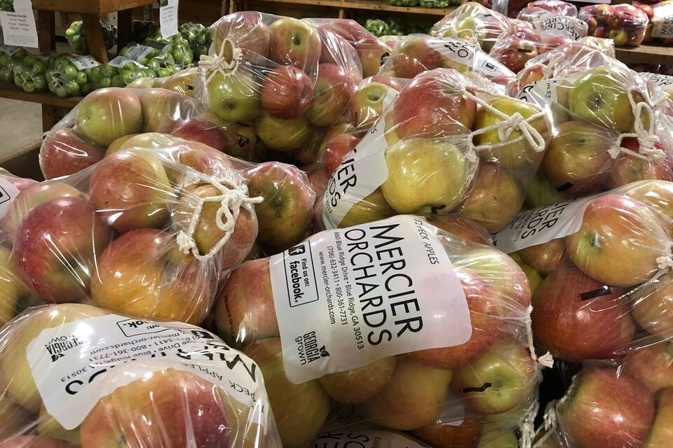 A grocery store with bags of apples labeled 'Mercier Orchards'.