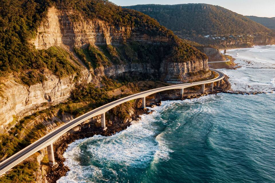 A coastal highway with cliffs and ocean waves.