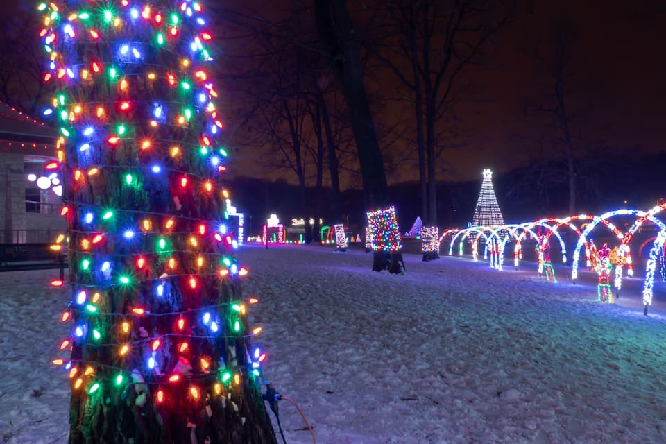 A snow-covered park with illuminated trees and structures.