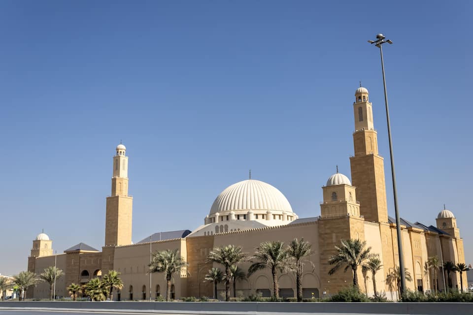 Uma grande mesquita com uma cúpula imponente e duas minaretes.