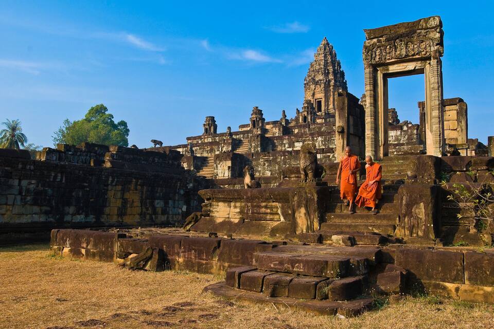 Ancient stone ruins with a large, ornate doorway and a temple structure.