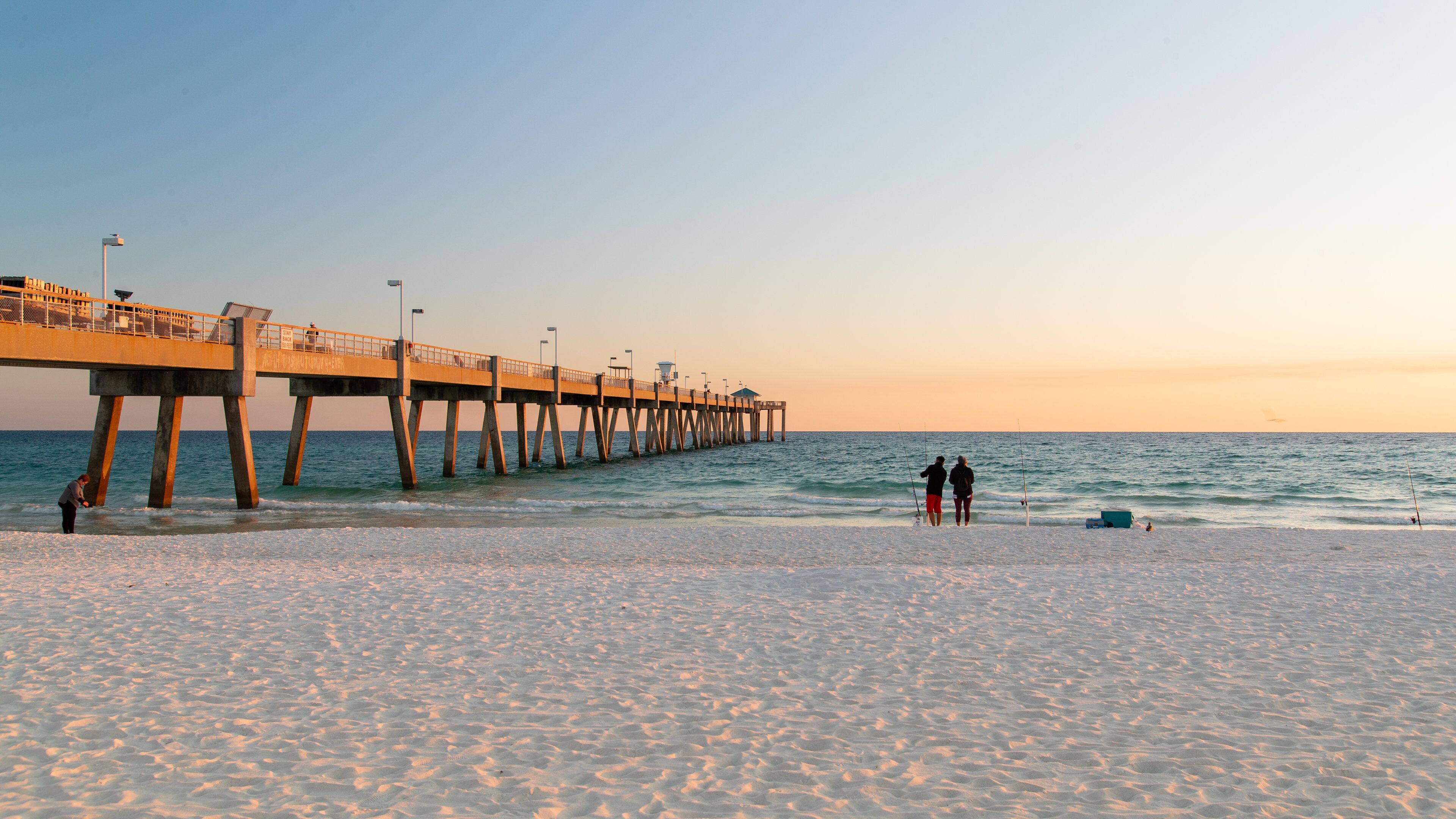 Okaloosa Island Pier which includes a sunset, general coastal views and a beach