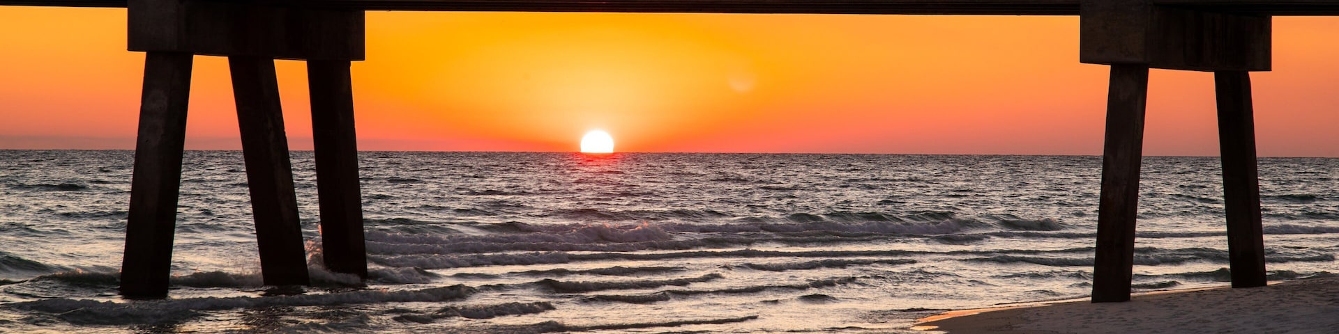 Okaloosa Island Pier which includes general coastal views, a sunset and a bridge