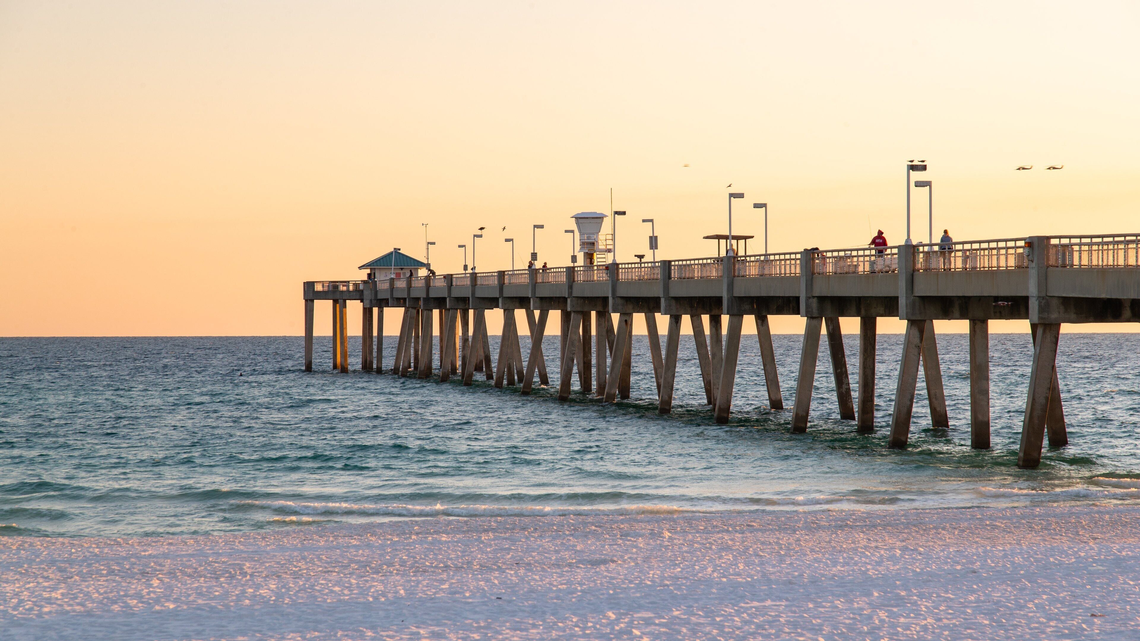 Okaloosa Island Pier featuring a sunset, general coastal views and a sandy beach