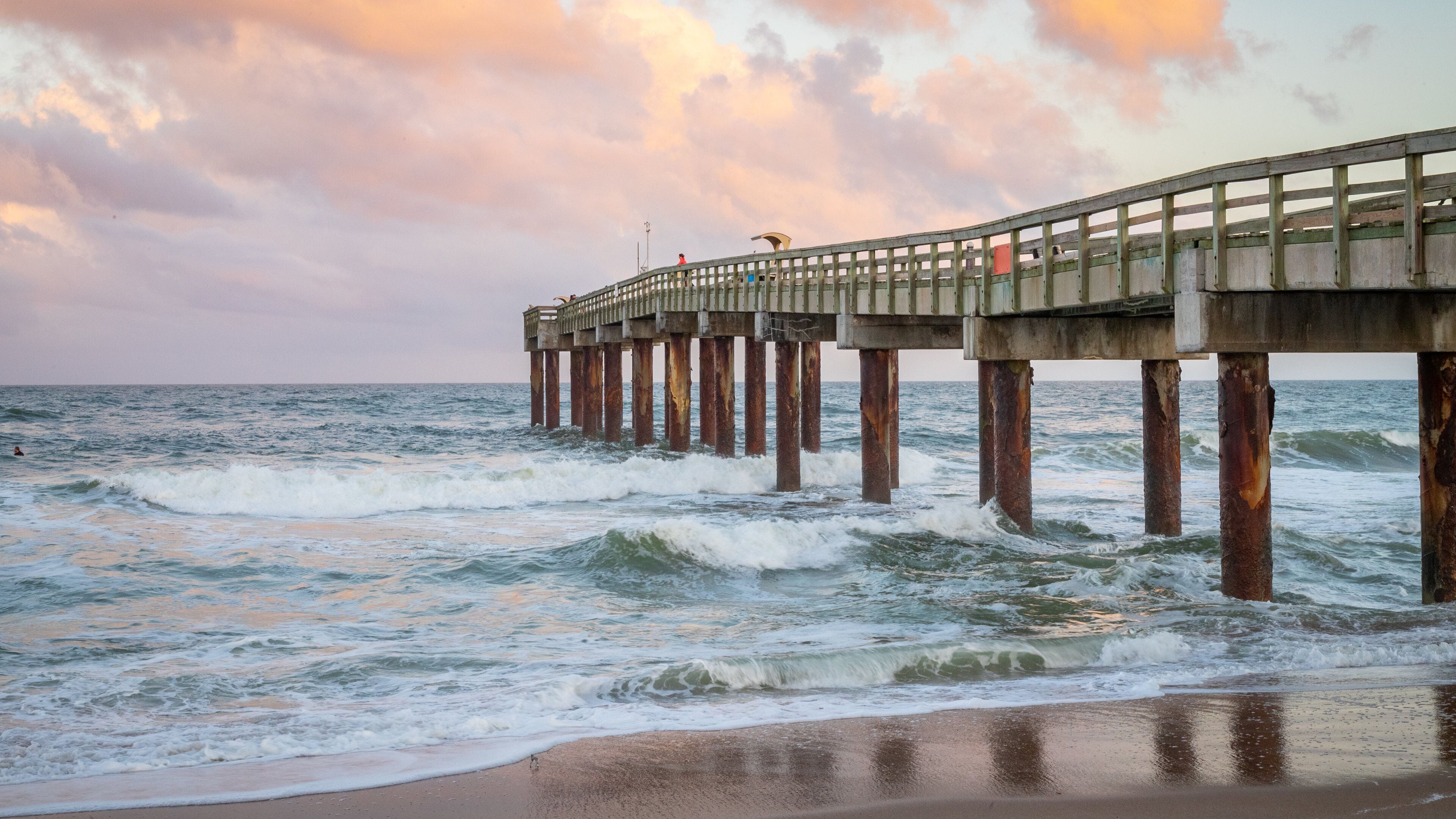 St. Johns County Ocean Pier showing a sunset, general coastal views and a beach