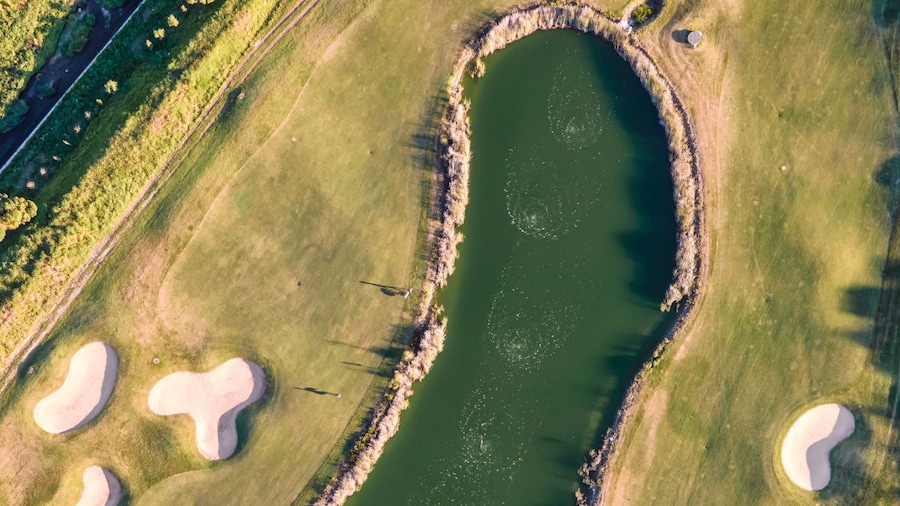 Aerial view of the golf court with a small lake in the field, view of the country sport club in Cruz Quebrada-Dafundo, Lisbon, Portugal.