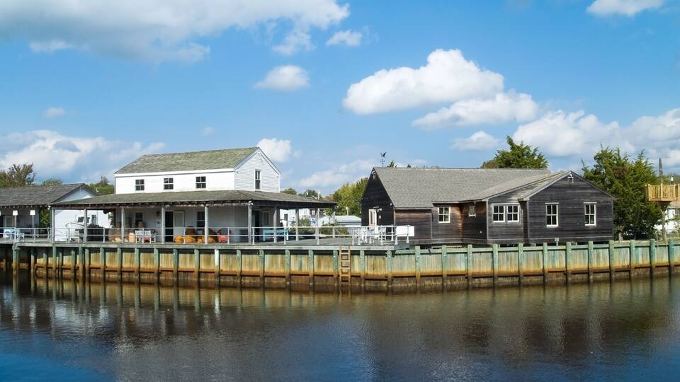 A waterfront with a white building and a wooden structure.