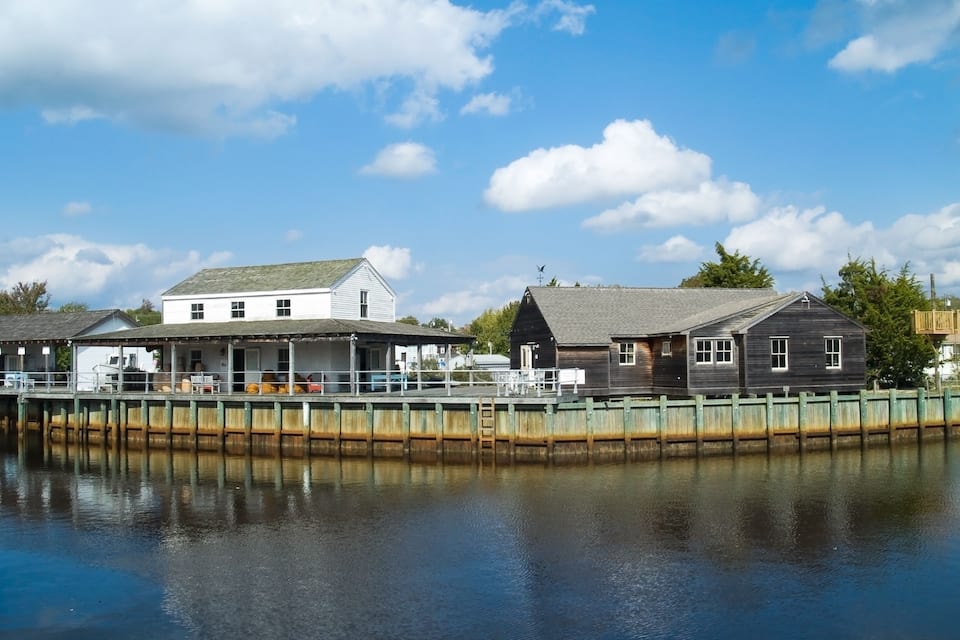 A waterfront with a white building and a wooden structure.