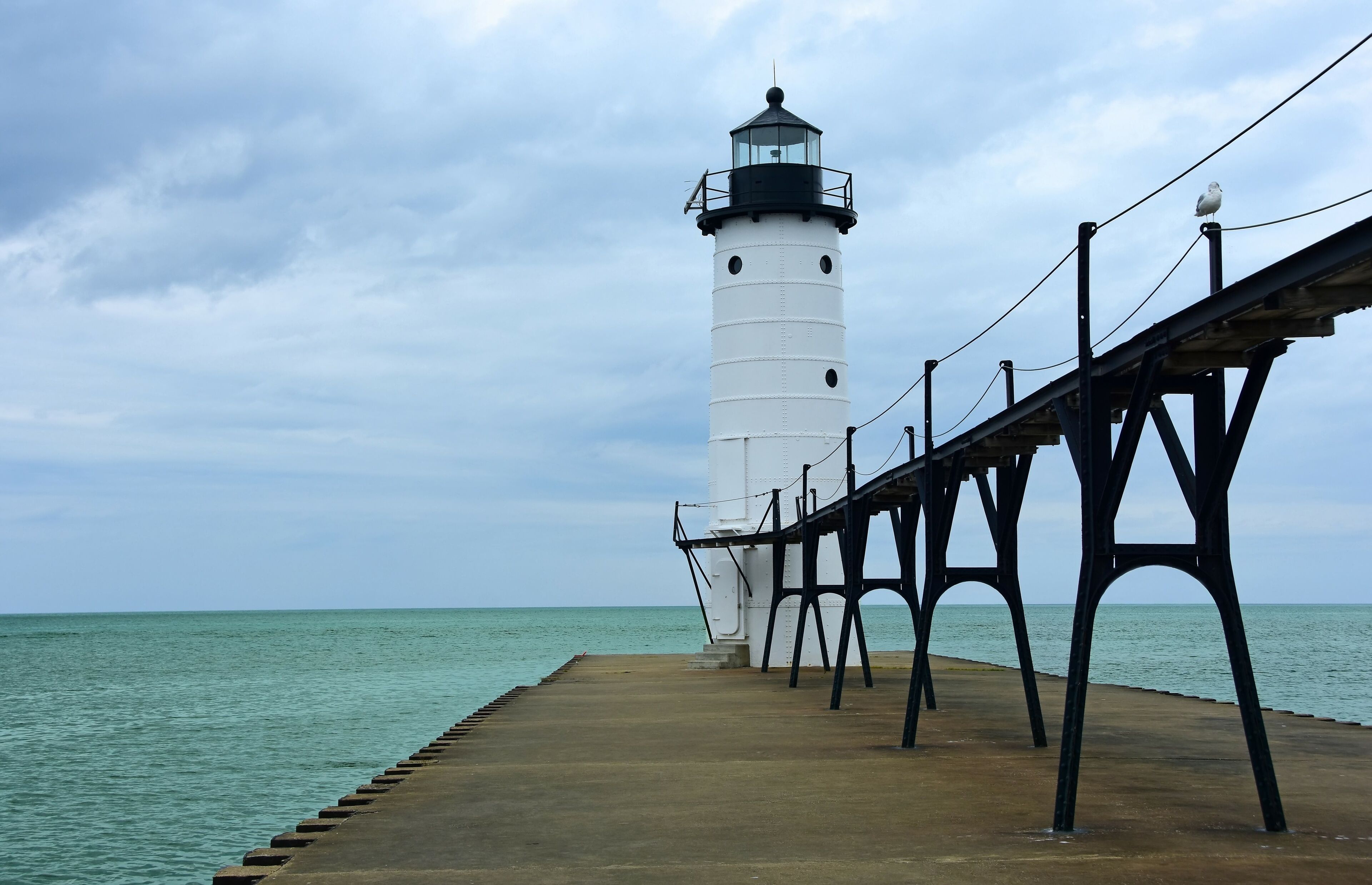 the historic manistee north pierhead lighthouse on fifth avenue beach on eastern lake michigan, michigan, with its elevated  walkway, on a stormy day