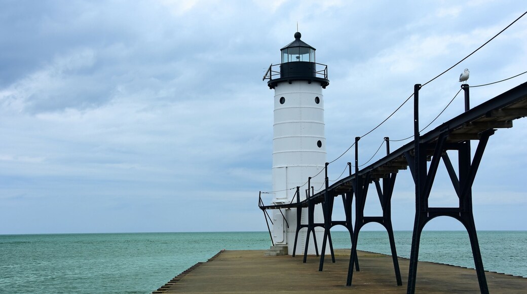 the historic manistee north pierhead lighthouse on fifth avenue beach on eastern lake michigan, michigan, with its elevated walkway, on a stormy day