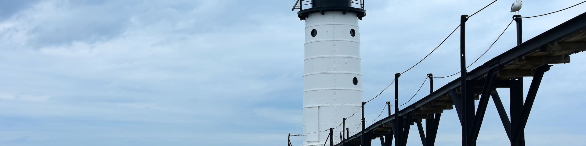 the historic manistee north pierhead lighthouse on fifth avenue beach on eastern lake michigan, michigan, with its elevated walkway, on a stormy day