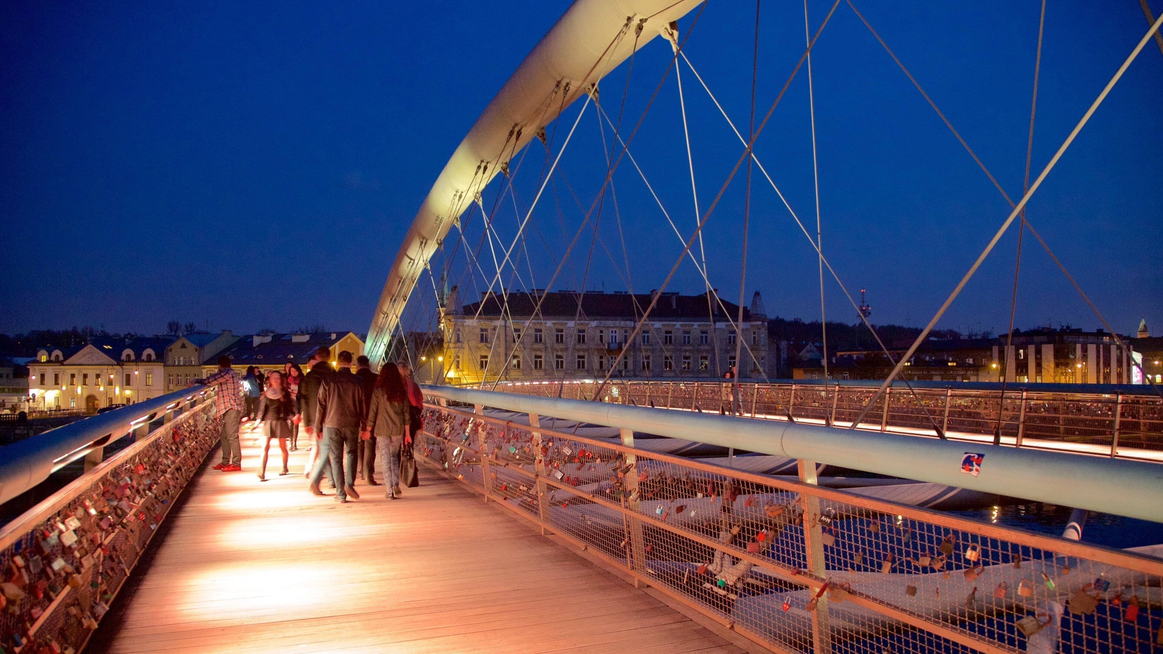 Father Bernatka Footbridge som inkluderer nattbilder og bro i tillegg til en liten gruppe med mennesker