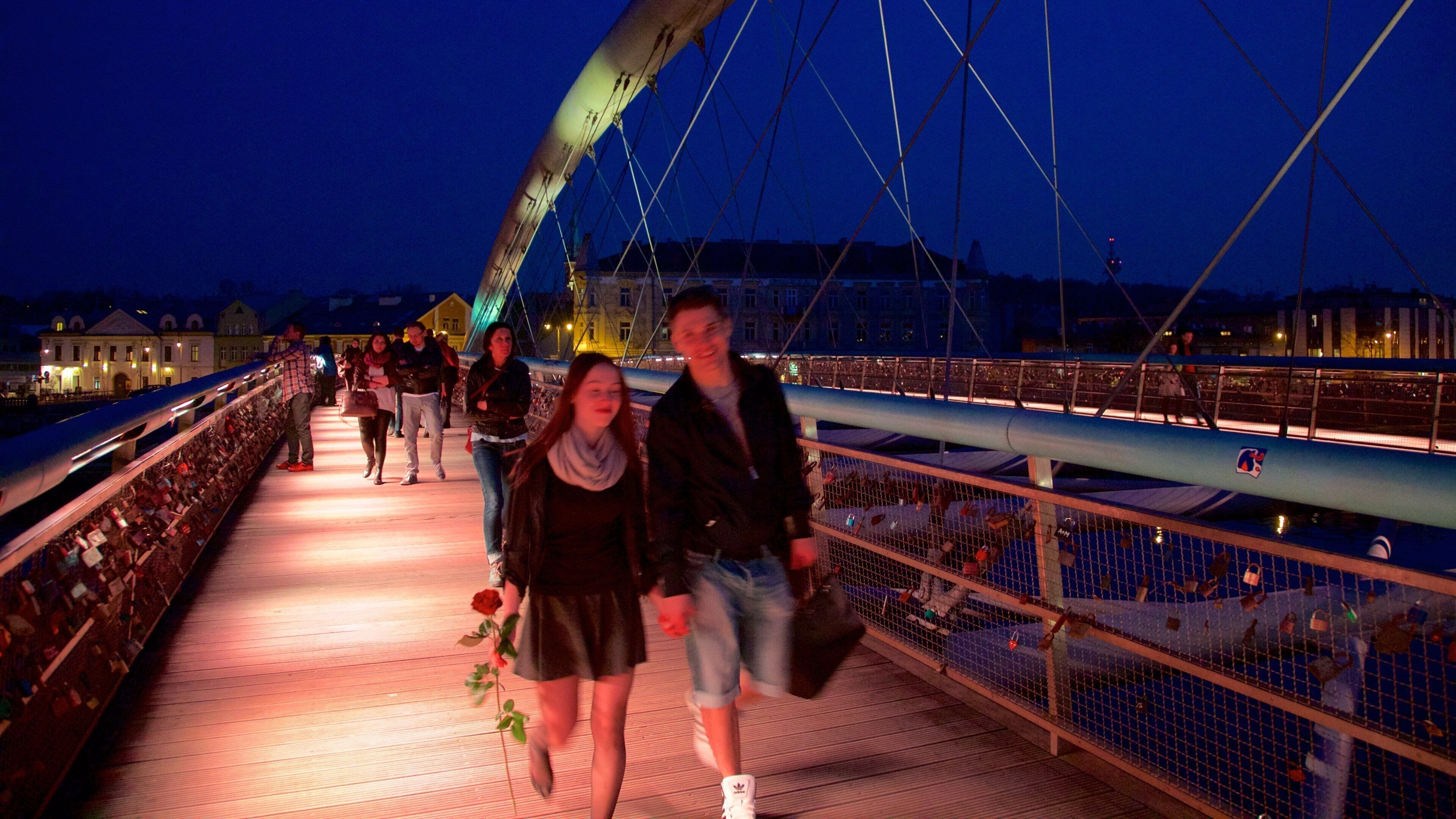Cracovia ofreciendo escenas de noche y un puente y también una pareja