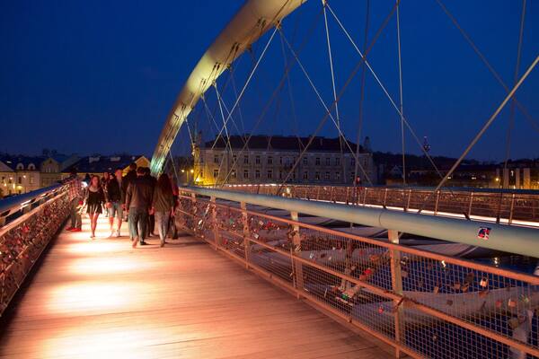 Father Bernatka Footbridge featuring night scenes and a bridge as well as a small group of people