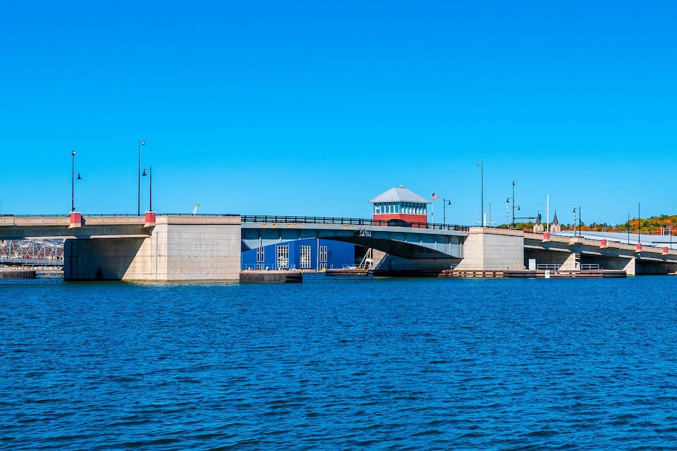 Un pont enjambant une étendue d’eau, doté d’une tour de contrôle et de feux de signalisation.
