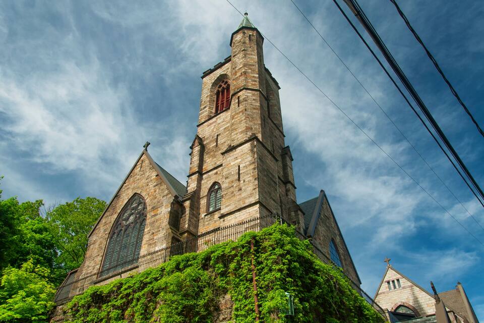 Una iglesia histórica con una torre alta y ventanas de arco.