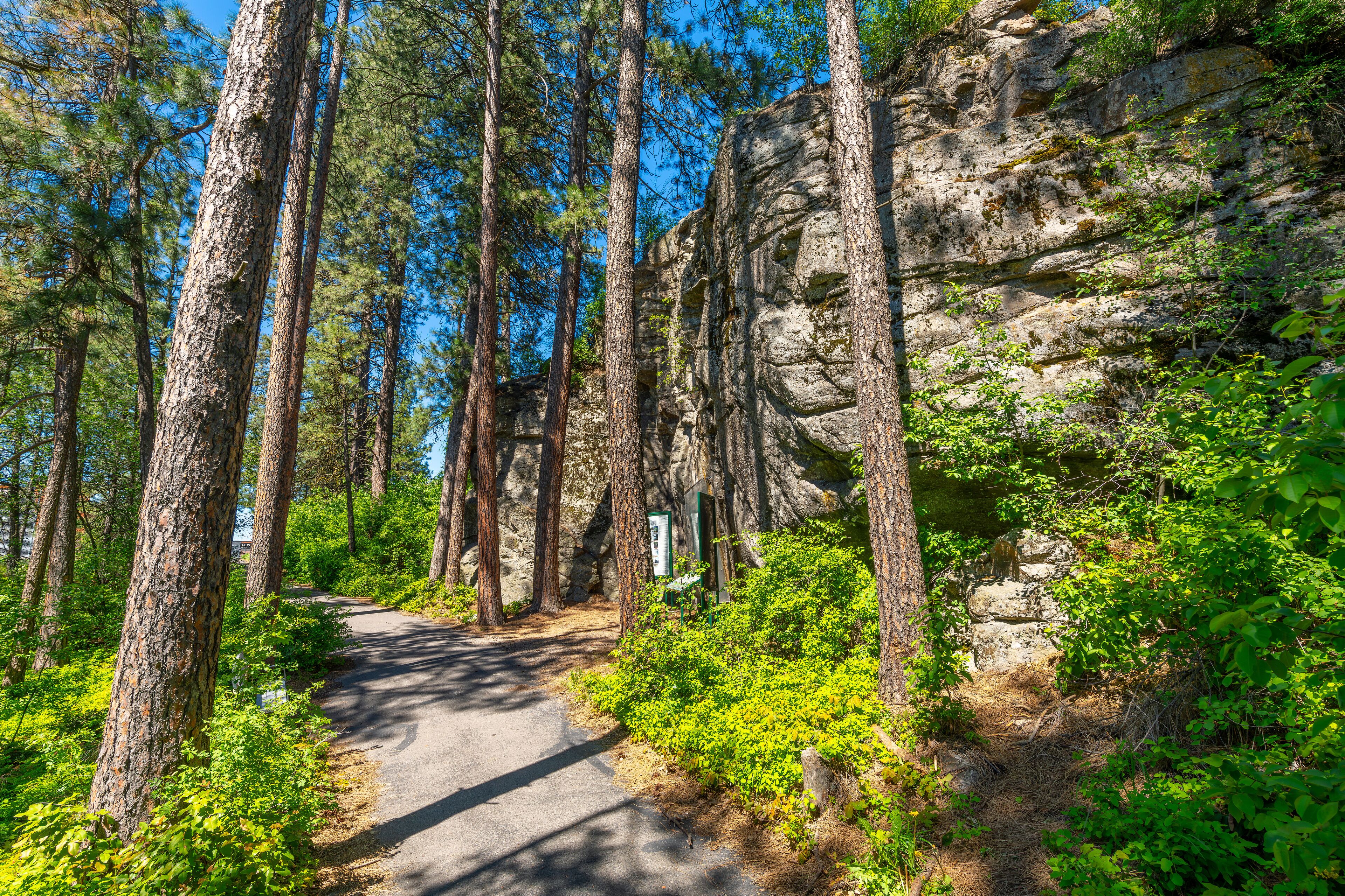 The wooded trail through the public Falls Park leading to the historic Treaty Rock a rock wall with a painted written compact between Frederick Post, a settler, and the Native American tribes in 1871.