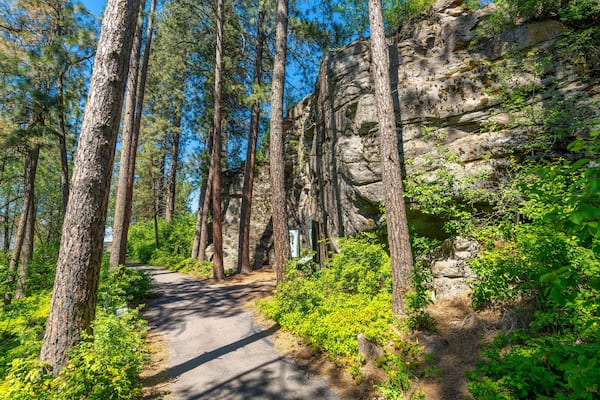 The wooded trail through the public Falls Park leading to the historic Treaty Rock a rock wall with a painted written compact between Frederick Post, a settler, and the Native American tribes in 1871.