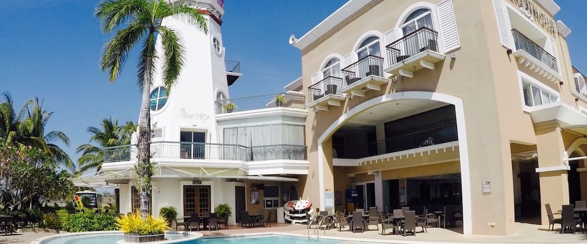Un complejo turístico con piscina, un faro y un edificio con balcones.