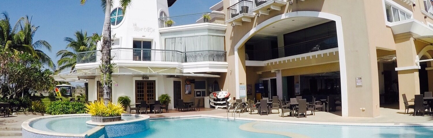 Un complejo turístico con piscina, un faro y un edificio con balcones.