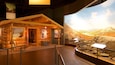 Una exhibición de una cabaña de troncos con un letrero de Northern Exposure, carteles informativos y un paisaje pintoresco de fondo.