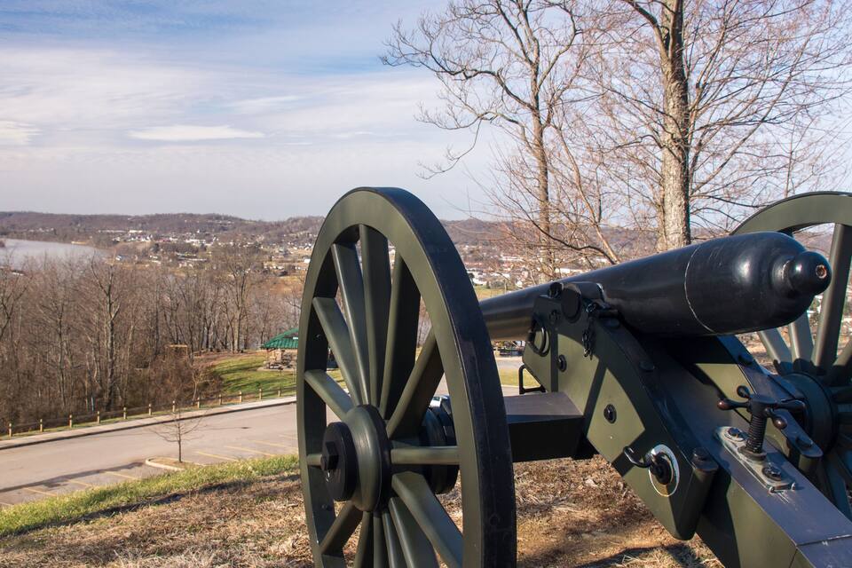 A cannon overlooking a town and a body of water.