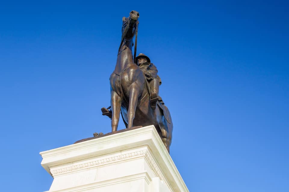 A statue of a man on horseback, mounted on a pedestal with inscriptions.