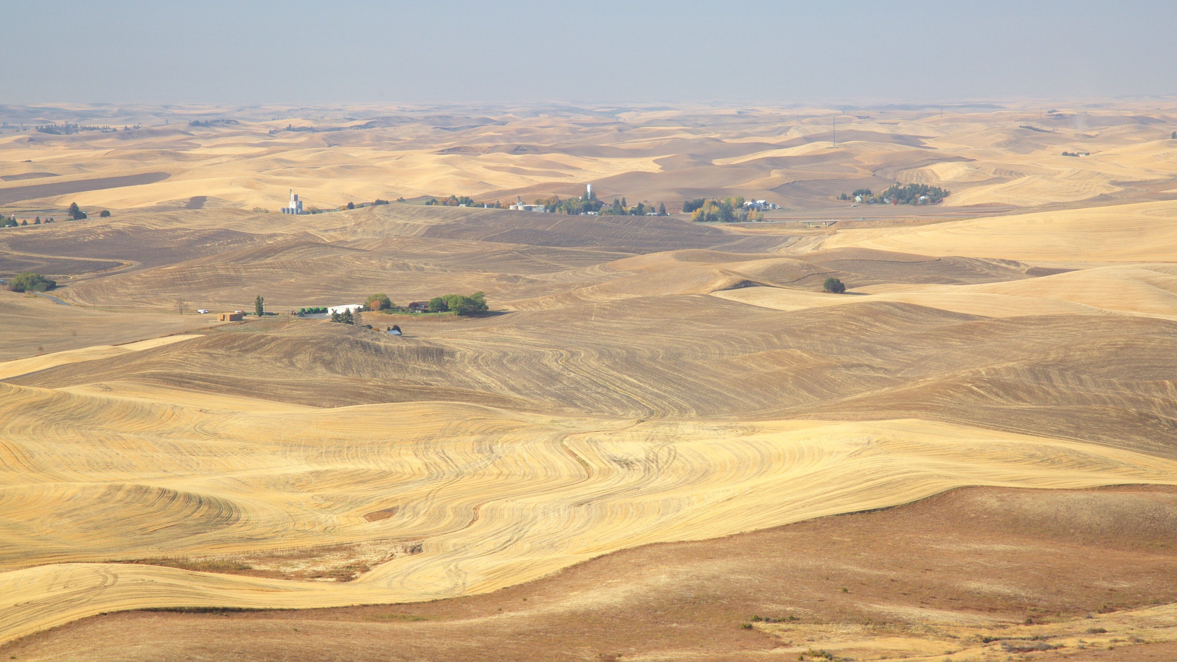Rolling hills and a small settlement with buildings.