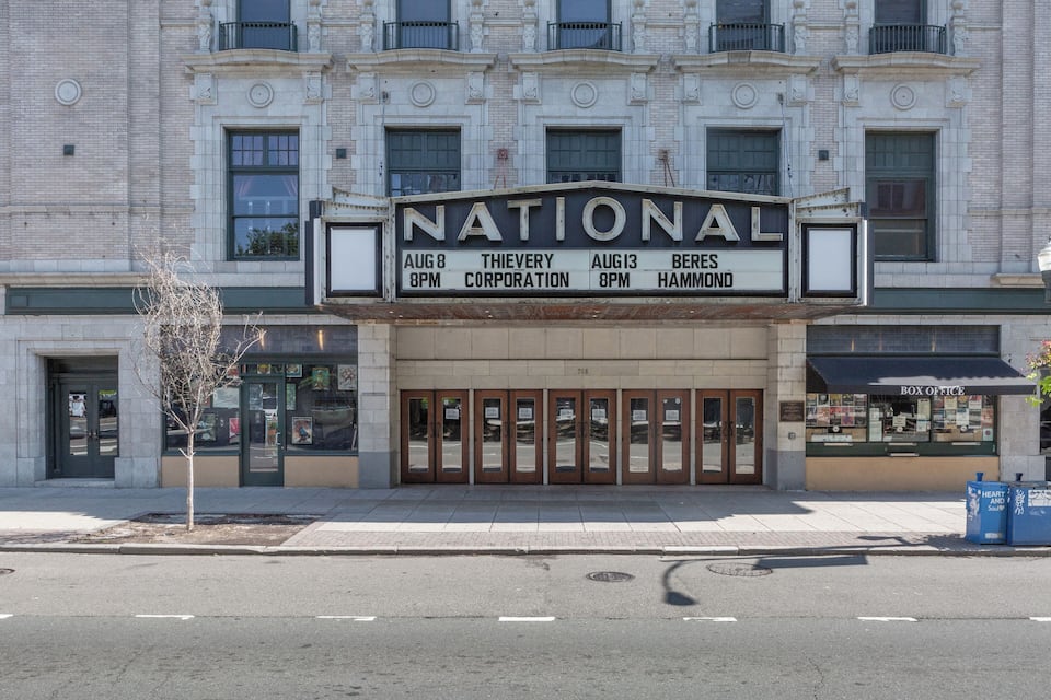 A theater marquee with "NATIONAL" and movie showtimes.