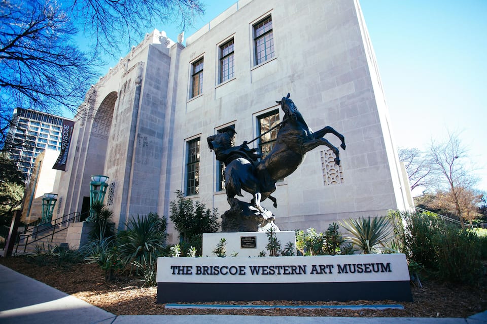 Museu de Arte Western Briscoe com uma estátua de um cavalo e um cavaleiro em frente.