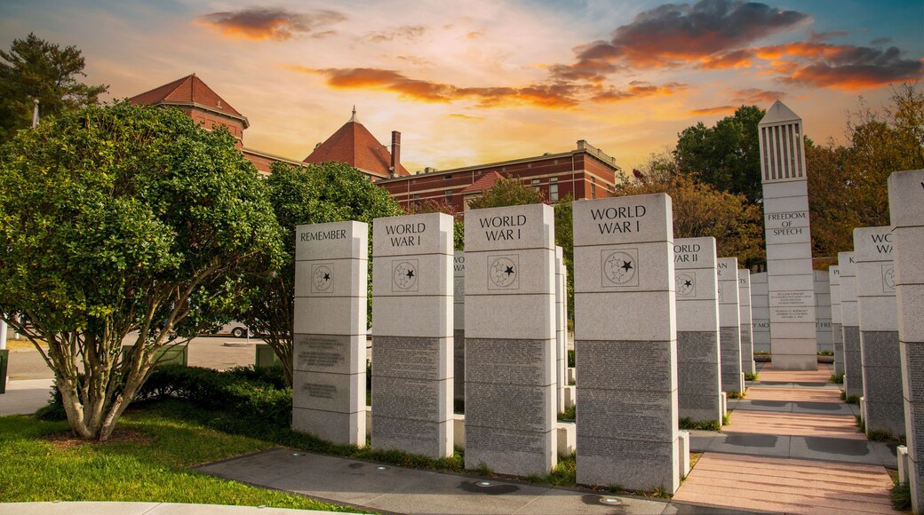 a gorgeous autumn landscape at East Tennessee Veterans Memorial in World's Fair Park with stone slabs surrounded by autumn colored trees and lush green trees and powerful clouds at sunset in Knoxville
