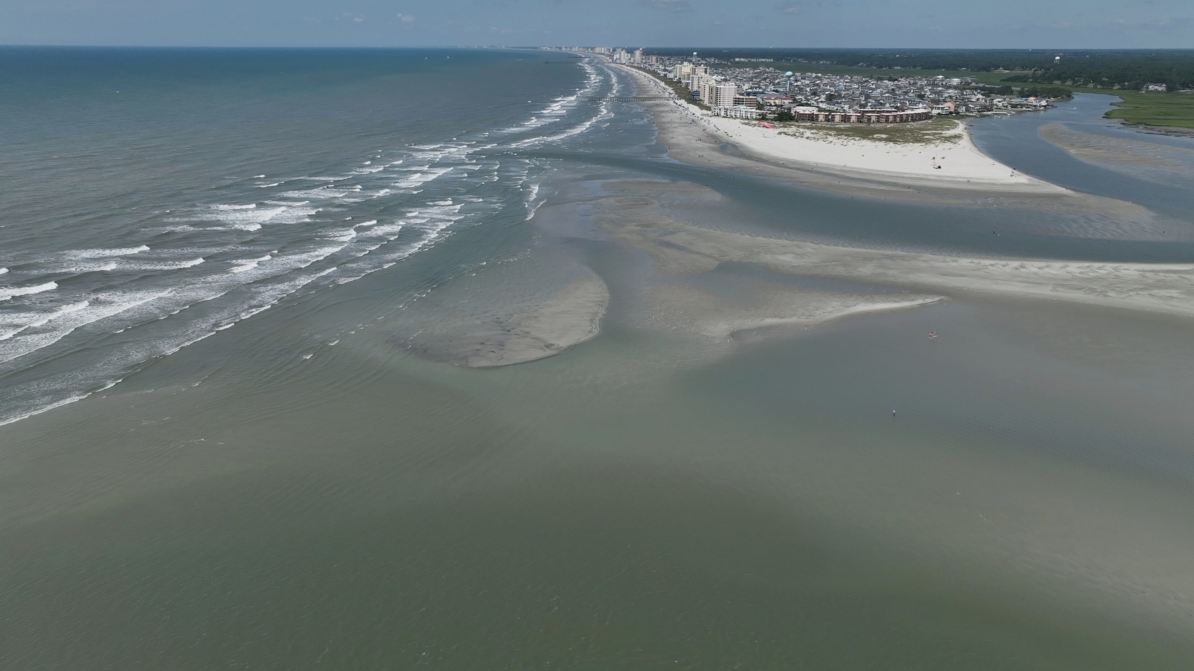 Vast sandbar at North end of Cherry Grove Beach where people sunbath on beautiful beach while on summer vacation at North Myrtle Beach in South Carolina