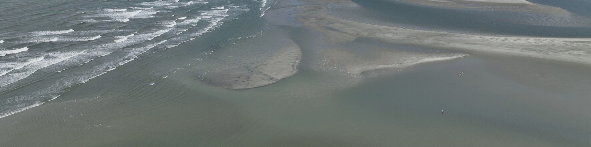 Vast sandbar at North end of Cherry Grove Beach where people sunbath on beautiful beach while on summer vacation at North Myrtle Beach in South Carolina