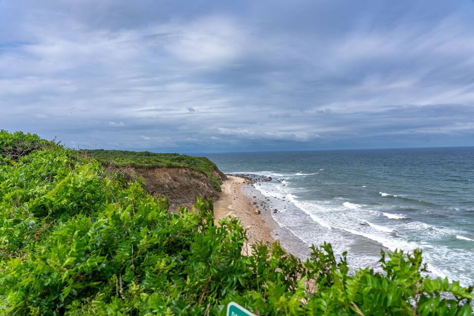 A coastal landscape with a beach, cliffs, and ocean waves.
